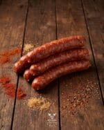 Beef sausage with paprika and spices on a rustic wooden surface – Boucherie Beirut Laval