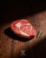 Wagyu ribeye steak 9+ raw with rich marbling on dark wood — halal Fullblood Wagyu at Boucherie Beirut, Laval
