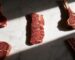 Raw Denver steak in the spotlight surrounded by ribeye and tomahawk cuts on marble – Boucherie Beirut Laval
