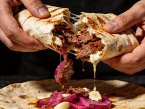 Wrap de shawarma de bœuf ouvert révélant du bœuf grillé épicé sauce à l'ail et oignons marinés – Boucherie Beirut Laval