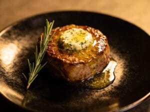 Filet mignon with melting herb butter and rosemary on a dark plate for a special occasion – Boucherie Beirut Laval