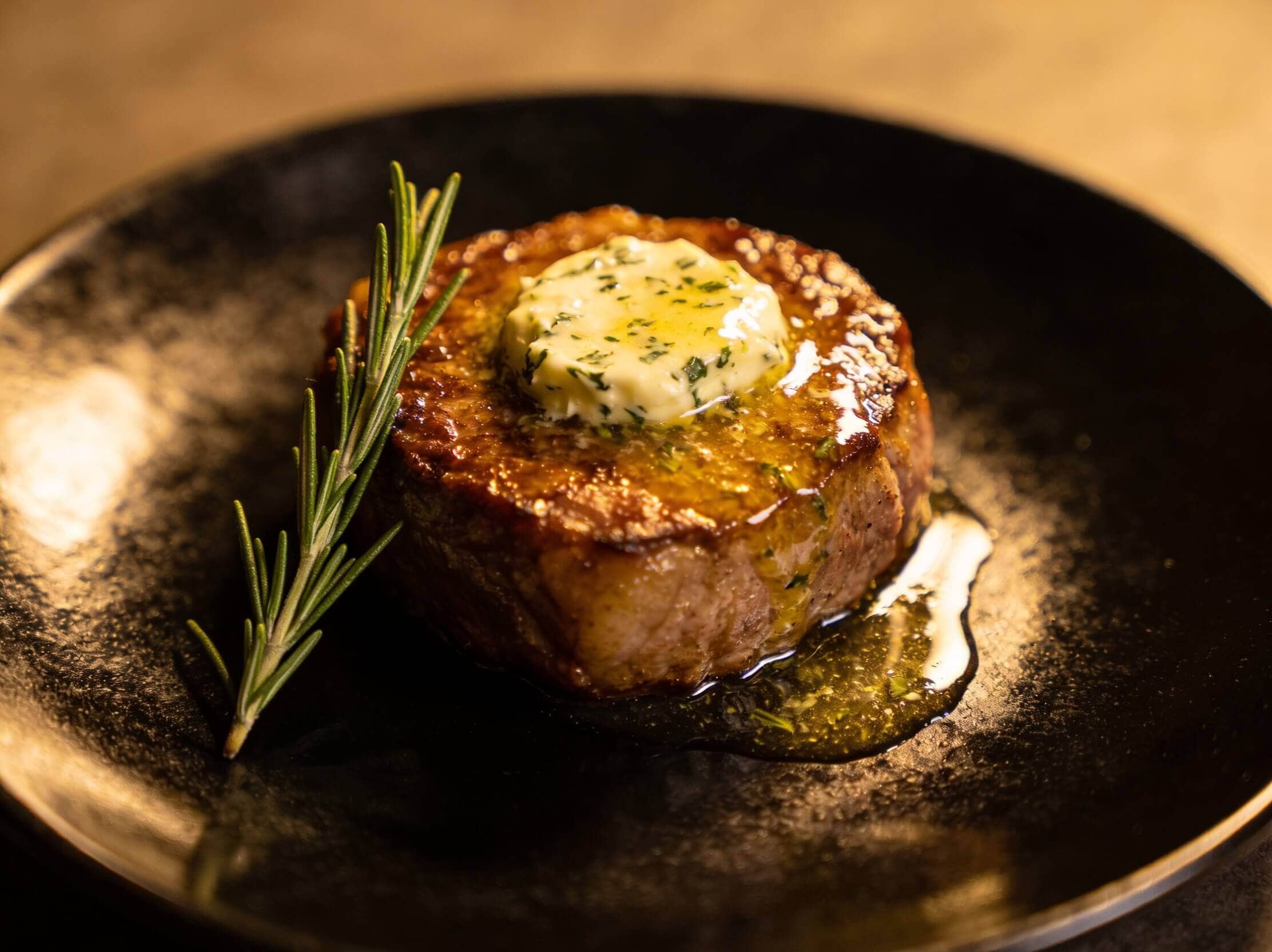 Filet mignon avec beurre aux herbes fondant et romarin sur une assiette sombre pour une occasion spéciale – Boucherie Beirut Laval