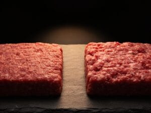 Lean and medium ground beef patties side by side on a dark slate surface showing fat content difference – Boucherie Beirut Laval