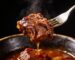 Best cuts for slow cooking fork tender braised beef lifted from a dark bowl with braising sauce dripping – Boucherie Beirut Laval
