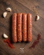 Italian spicy beef sausage with fennel seeds chili flakes and garlic on a rustic wooden surface – Boucherie Beirut Laval