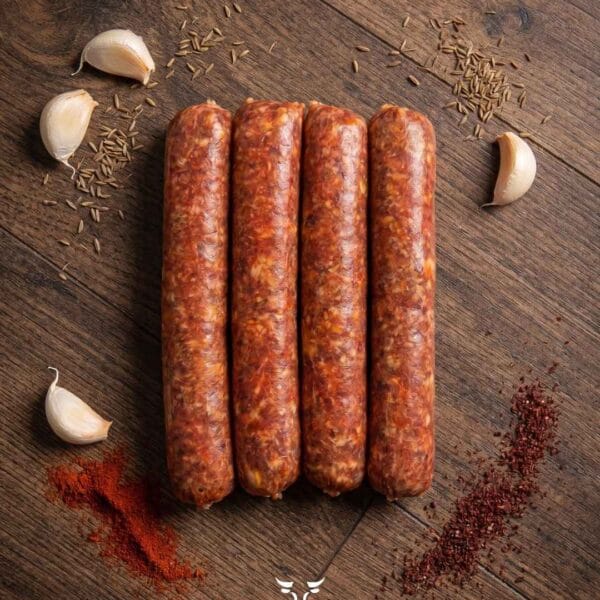 Italian spicy beef sausage with fennel seeds chili flakes and garlic on a rustic wooden surface – Boucherie Beirut Laval