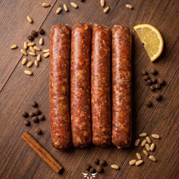 Makanek beef sausage with pine nuts cinnamon allspice and lemon on a rustic wooden surface – Boucherie Beirut Laval