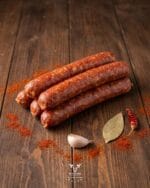 Portuguese beef sausage with with paprika garlic bay leaf and red chili on a rustic wooden surface – Boucherie Beirut Laval