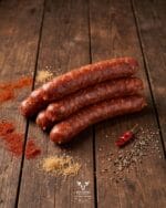 Smoked meat beef sausage with coriander mustard seeds and black pepper on a rustic wooden surface – Boucherie Beirut Laval