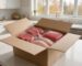 Halal meat delivery box opened on a kitchen island with fresh beef steaks, ground beef and chicken breasts