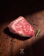 Wagyu ribeye 8-9 steak, raw with rich marbling on dark wood, halal meat delivery across Greater Montreal
