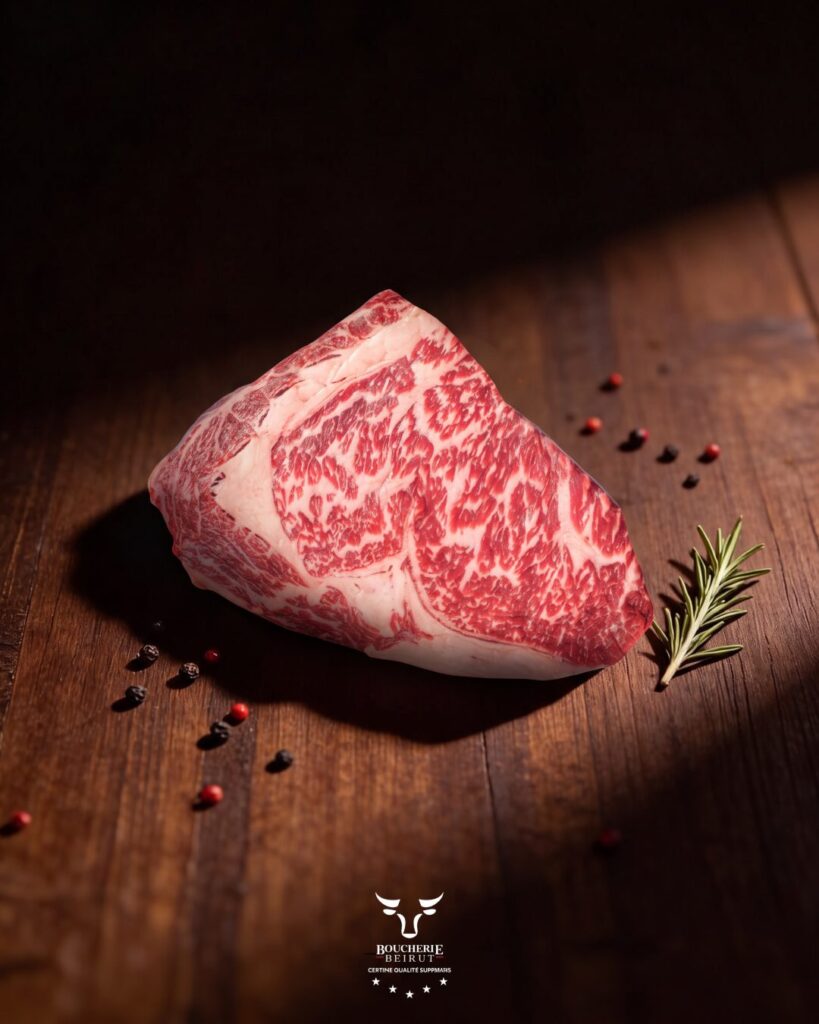 Wagyu 8-9 Ribeye Steak on promotion, raw marbled Wagyu on dark wood at Boucherie Beirut, Laval